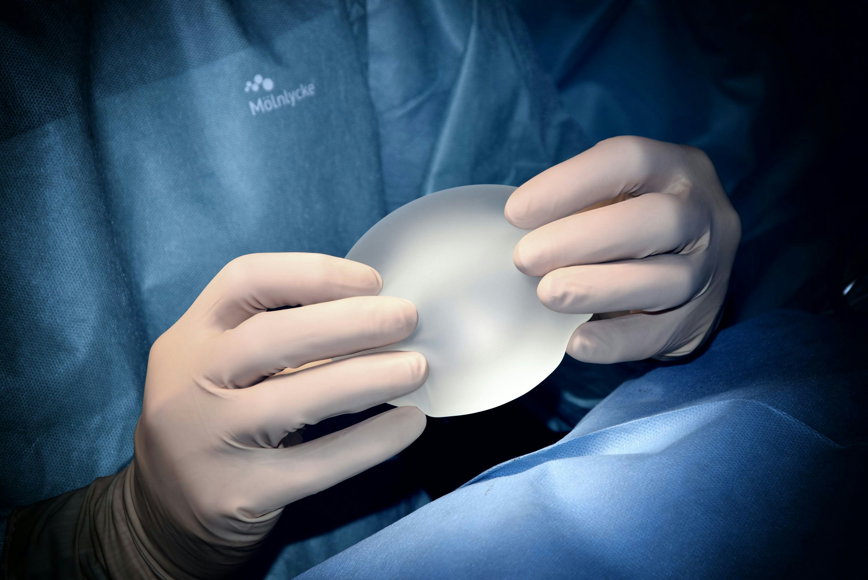 Medical professional holding breast implant